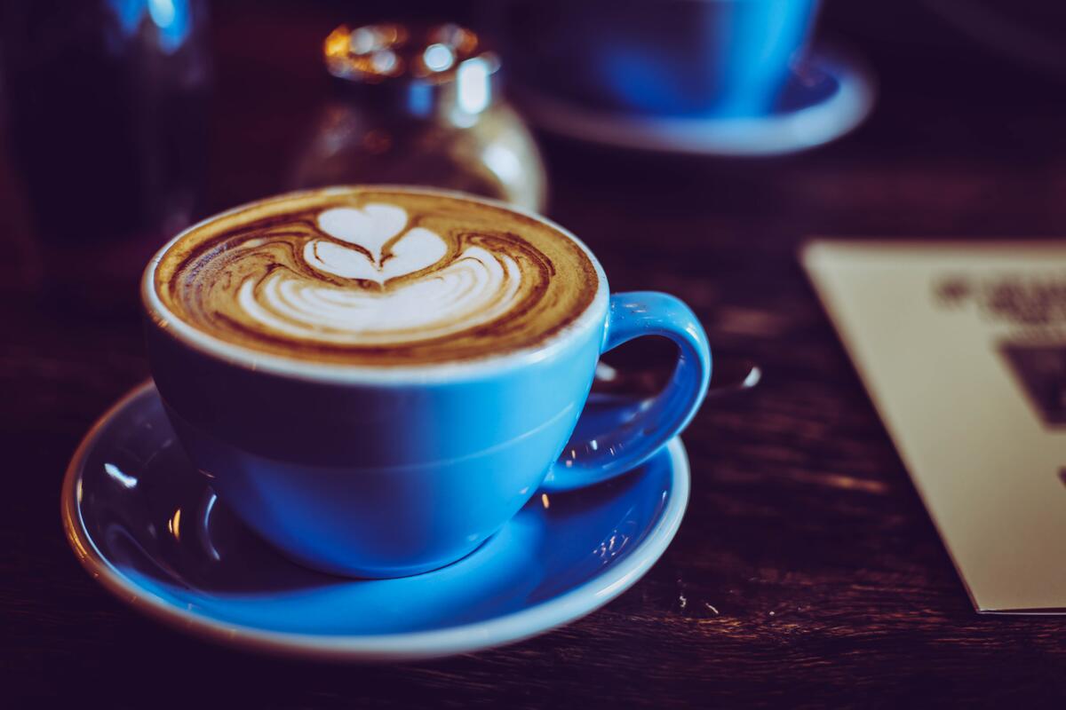 Bildet viser en blå kaffekopp med melkeskum