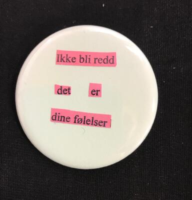 En hvit pin med rosa tekst. Det står Ikke bli redd - det er dine følelser.. Foto/Photo