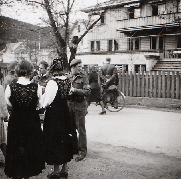 Bunadkledde jenter og soldatar utanfor Fagerlund Hotell, våren 1945.