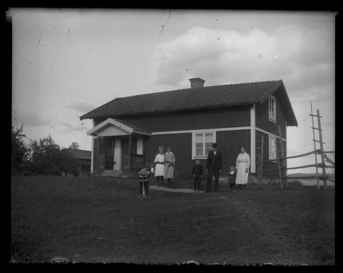 Grupporträtt, familj framför byggnad, Västervåla.
