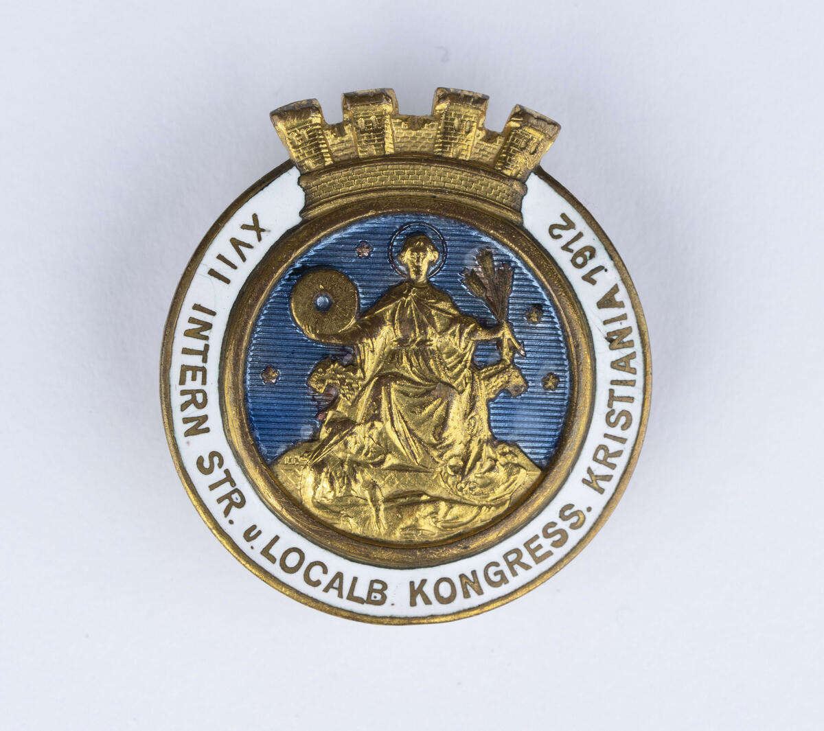 Jakkenål med Oslo, tidligere Kristiania, sitt byvåpen i gull, blått og hvitt. 