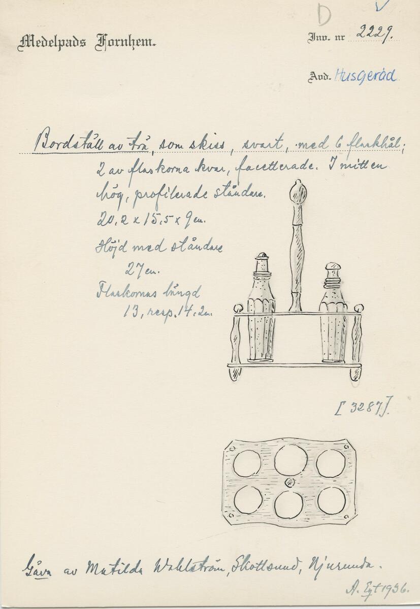 Bordsställ av trä. Svart, med 6 st flaskhål 2 av flaskorna kvar, facetterade. I mitten hög, profilerad ståndare. Flaskornas längd 13, resp 14,2 cm. Gåva av Matilda Walström, Skottsund, Njurunda. 

