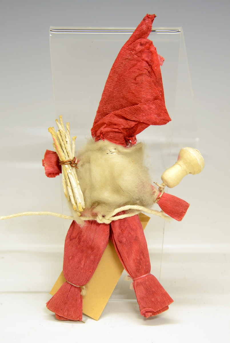 Nissefigur. Fra protokollen: Nissefigur laget av bl.a. kreppapir og bomull. Bærer et fange med "ved" tvunnet av papir, festet til figuren med messingtråd.