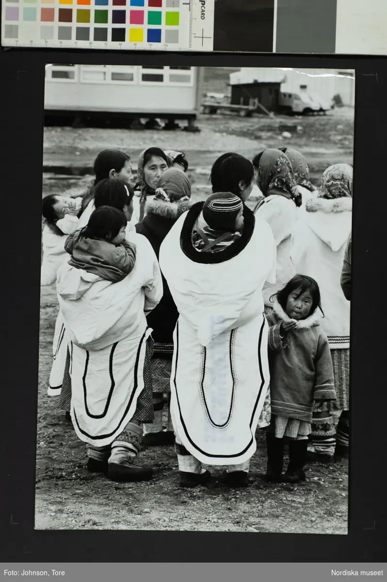 Kvinnor och barn i traditionall dräkt. Små barn bärs på ryggen. Inuitiska kvinnor och barn, Baffin Island, Canada.