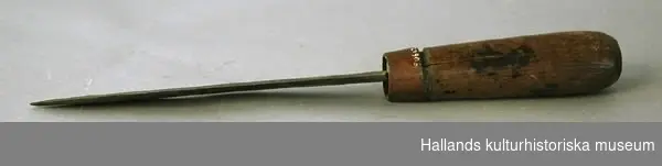Kniv av järn med svarvat handtag av ask. Med ring av koppar. (1,2 cm) som skoning. Längd 30,5 cm. Bredd (bladets största) 2,7 cm. 