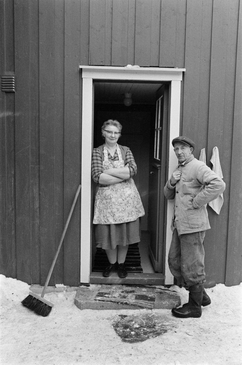 En kvinne og en mann i en døråpning.