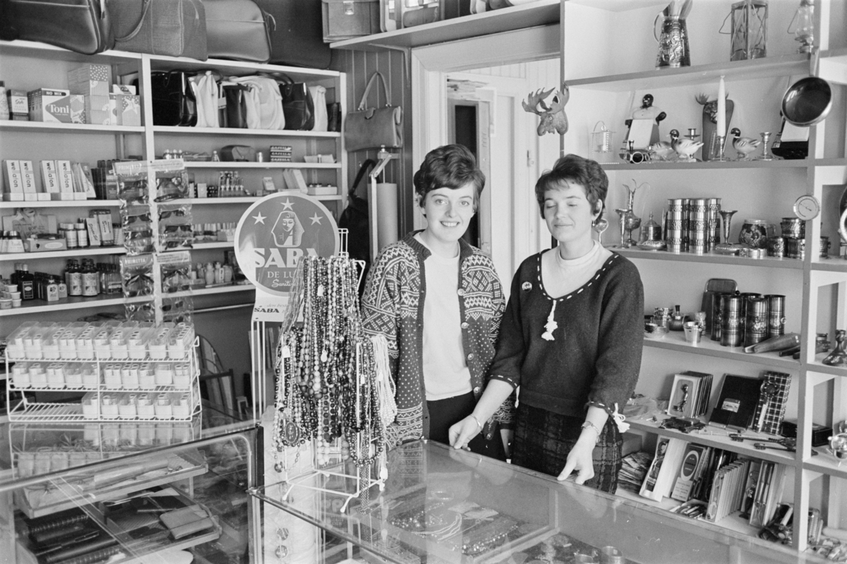 Portrett av to kvinner ved en butikksdisk.