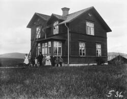 Två bilder på en familj framför glasverandan till sin bostad