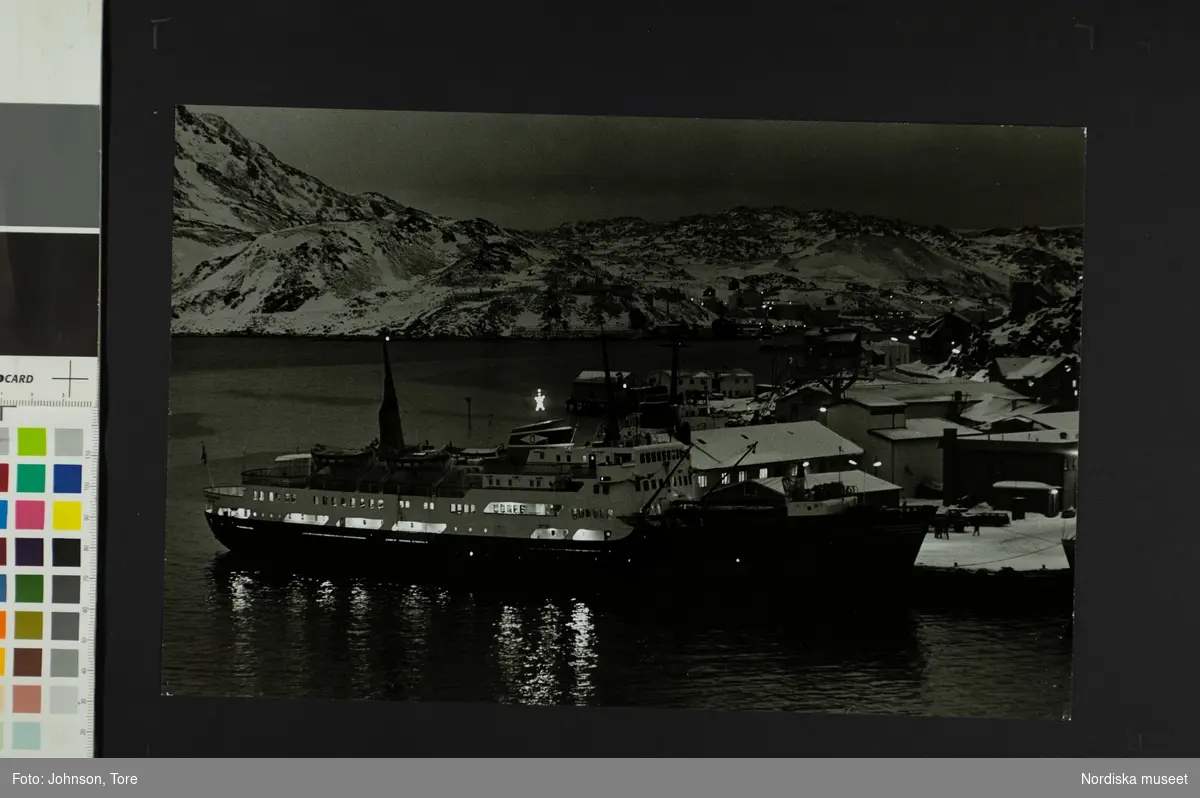 Ett fartyg ligger för ankar i en hamn. Hurtigrutt M/S anlöper Honningsvåg, Nordkap, Norge mitt på dagen i december månad.