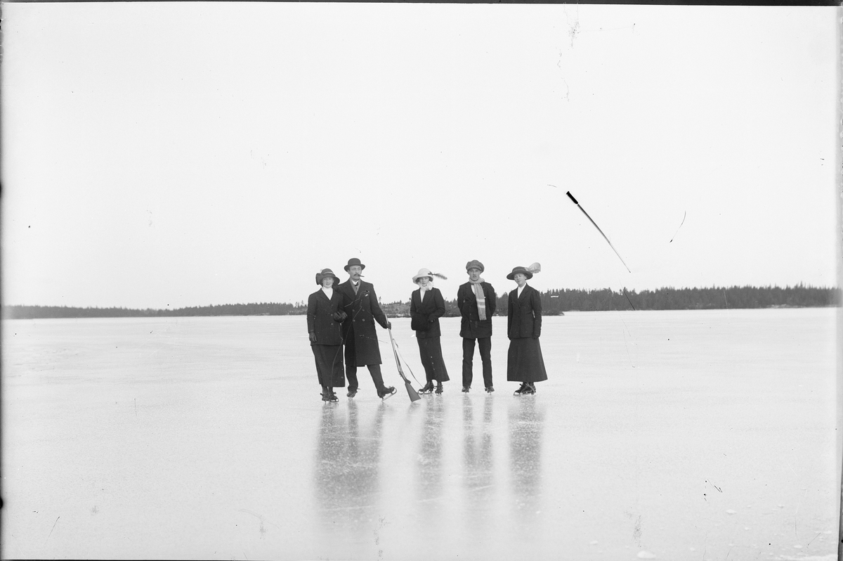 Kvinnor och män med skridskor ute på isen, Östhammar, Uppland