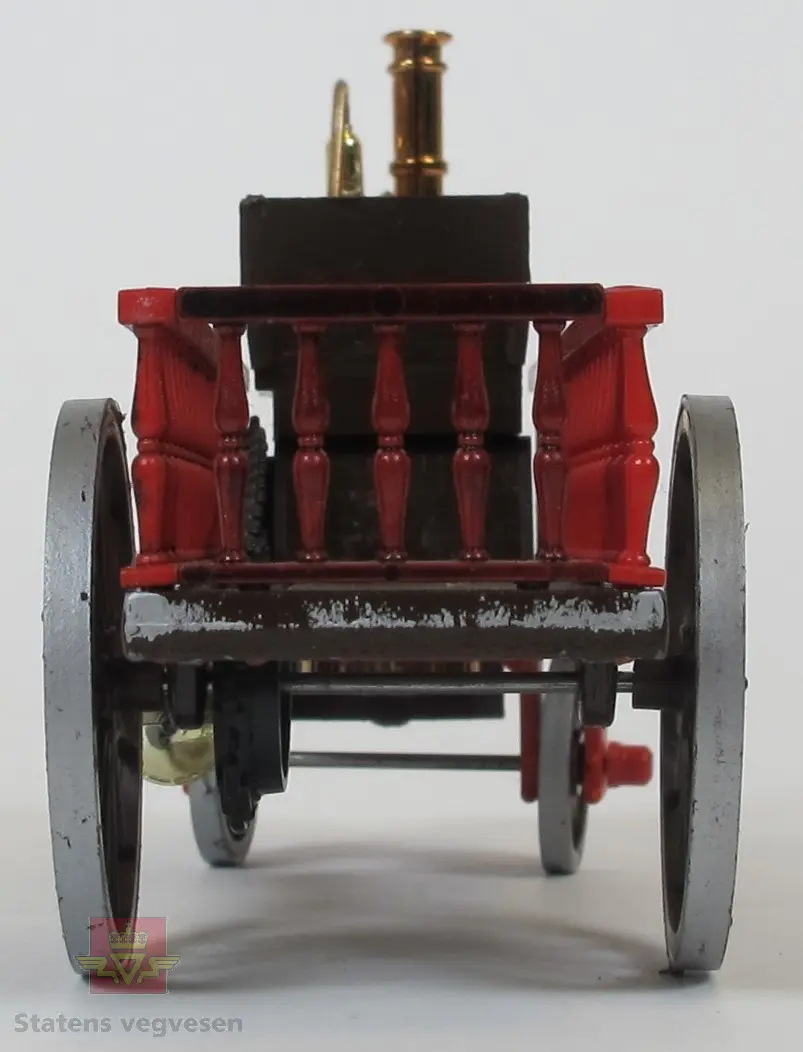 Hovedsakelig brun og rød dampvogn modell. Den har 2 akslinger der den fremste kan svinges. Dampmotoren er montert fremme på vogna, foran rattet og sete.