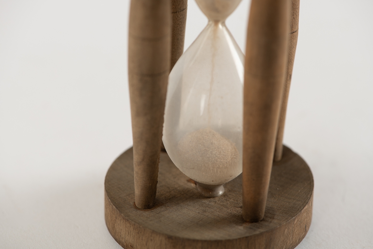 Timeglassform med fire tverrstenger av bjerk,  festet i sirkulære endestykker med fire   messingskruer. Sand som renner over på 14 sekunder.