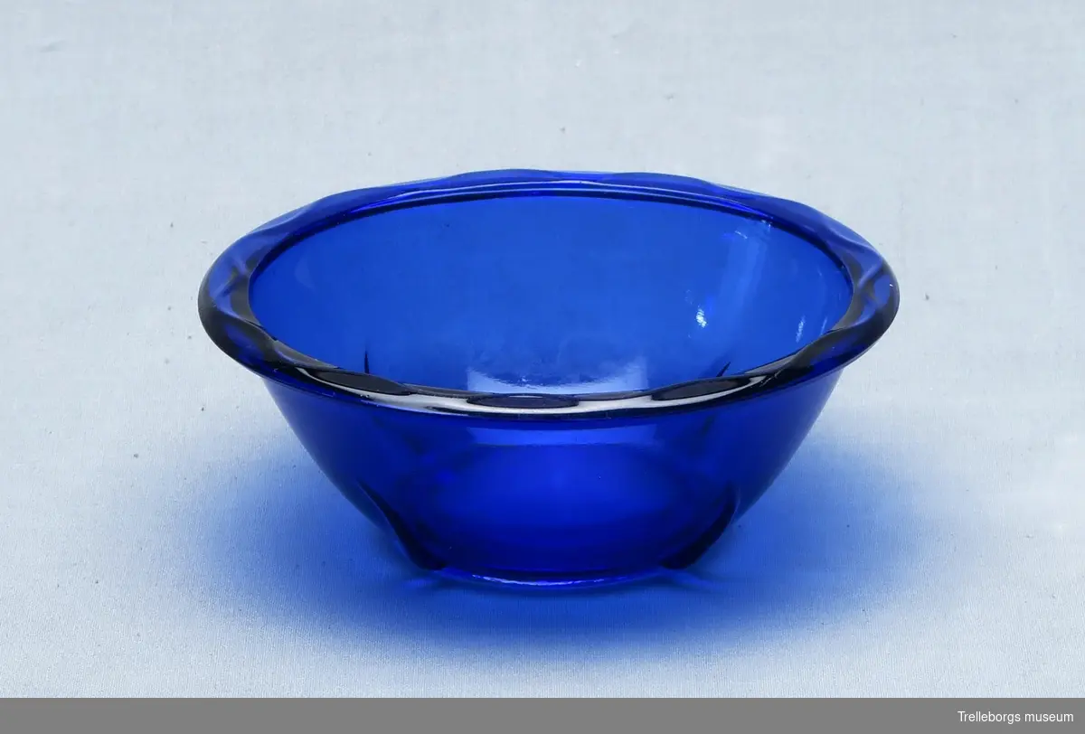 Mindre skål i blått glas. Droppformat mönster kring nederkanten.