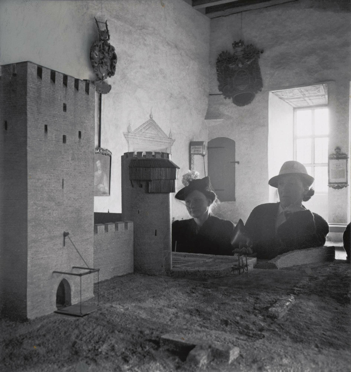 Interiör från Kalmar slott. Två kvinnor i hatt betraktar en modell av slottet som det såg ut år 1520.