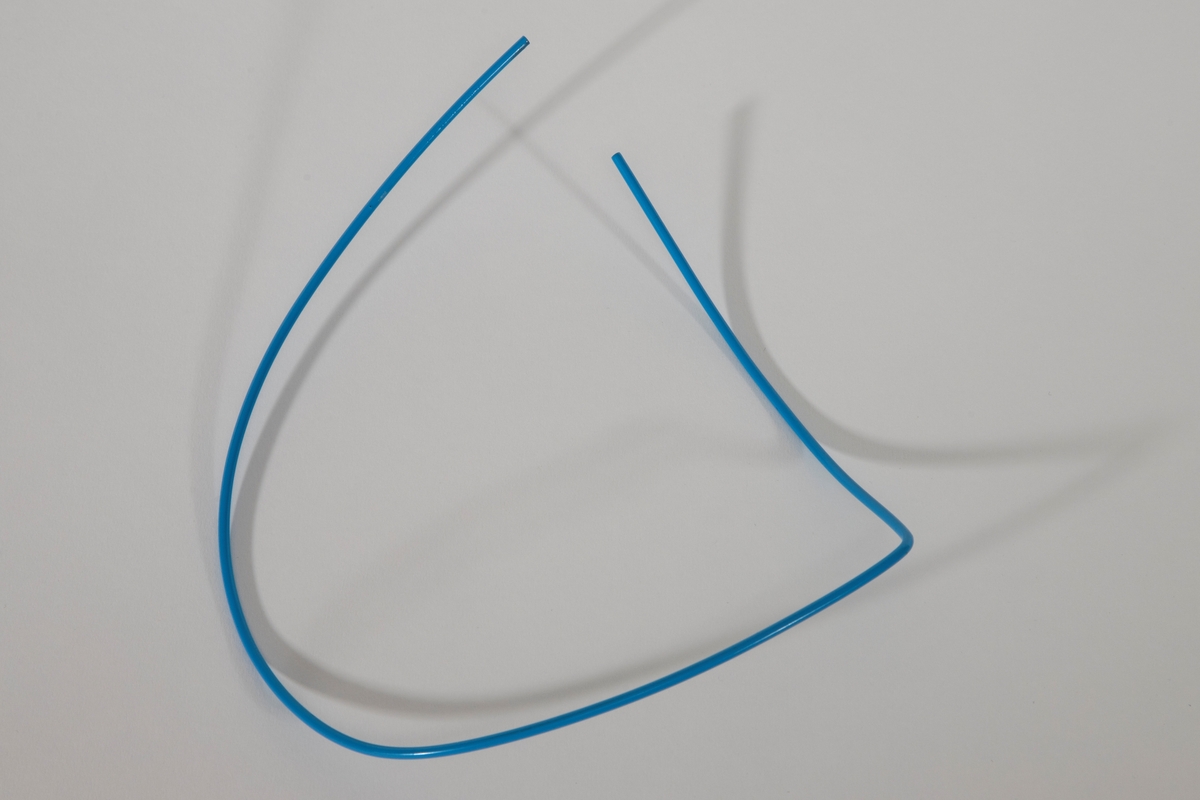 D-formet halssmykke, laget av tynn ståltråd dekket med blå plast. Smykket er åpent i den ene siden.