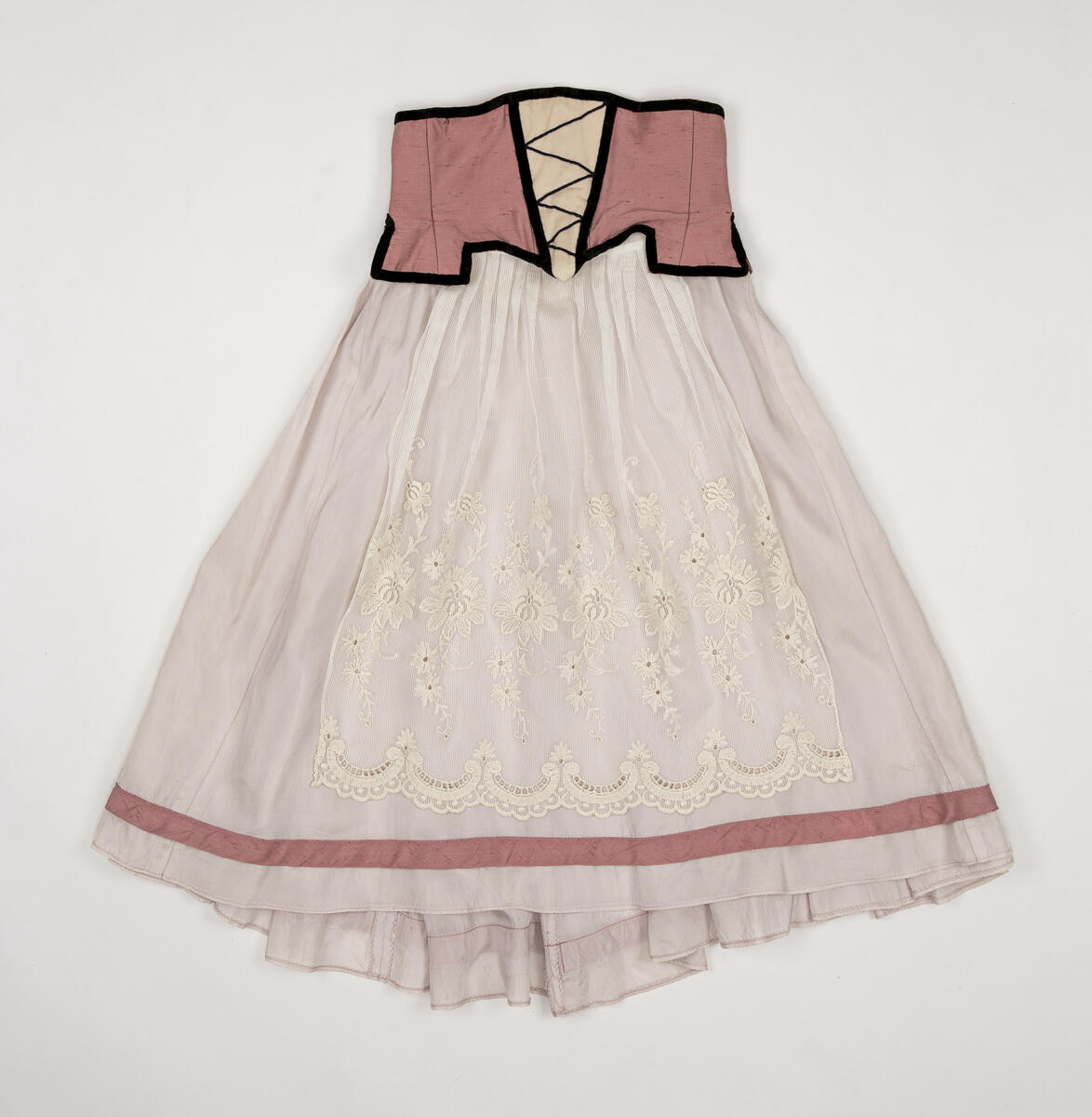 Kjol använd för rollen "Värdshusflicka" (en av flera)  i uppsättningen ”Pierrot i parken”.
Kjolen är tvådelad, dvs. kjolen består av ett korsettliv och en kjol som sytts ihop.
