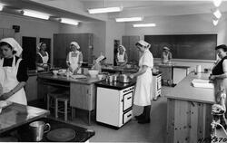 Elever og lærer på kjøkkenet ved Tinn kommunale husmorskole 