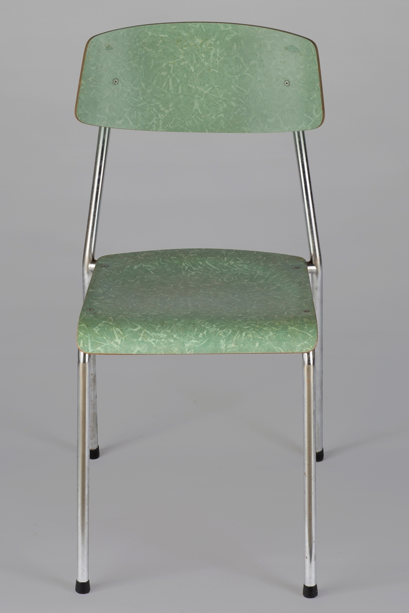 Stålrørsstol med åpen rygg. Sete og ryggplate av finer med grønn, marmorert respatex-overflate. Gummiknotter på bena.