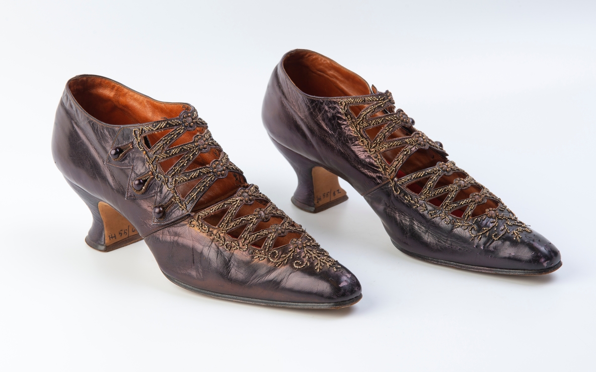 Mørk-fiolett, rødt trekk over sålene.
Stemplet under sålen: 1529 236(?)
Perlebroderi.
3 Knapper på hver sko.