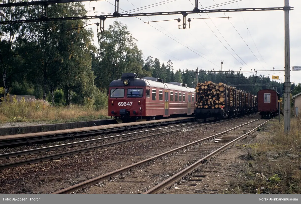 Elektrisk motorvognsett type 69, med styrevogn BS 69 647 fremst, med lokaltog fra Moss til Skøyen, tog 1128, i spor 1 på Såner stasjon. Kryssende tømmertog i spor 2. Dette var siste dag med ordinær drift på denne strekningen