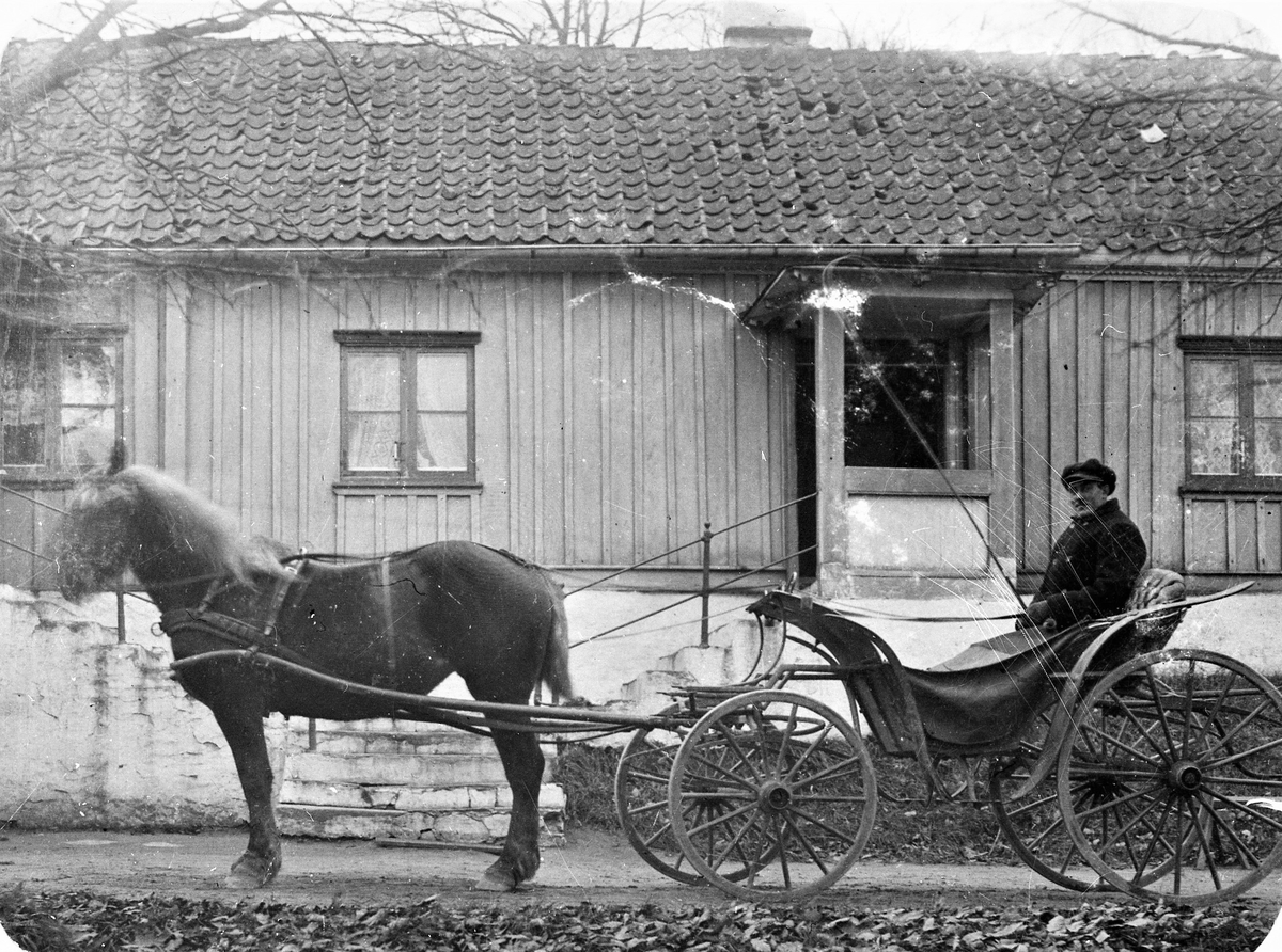 Arrendatorn av Veddige Prästgård, Johan Svensson, sitter i hästdragen vagn vid folkskolan i Sällstorp, Lugnet. Skolan stod klar 1865.