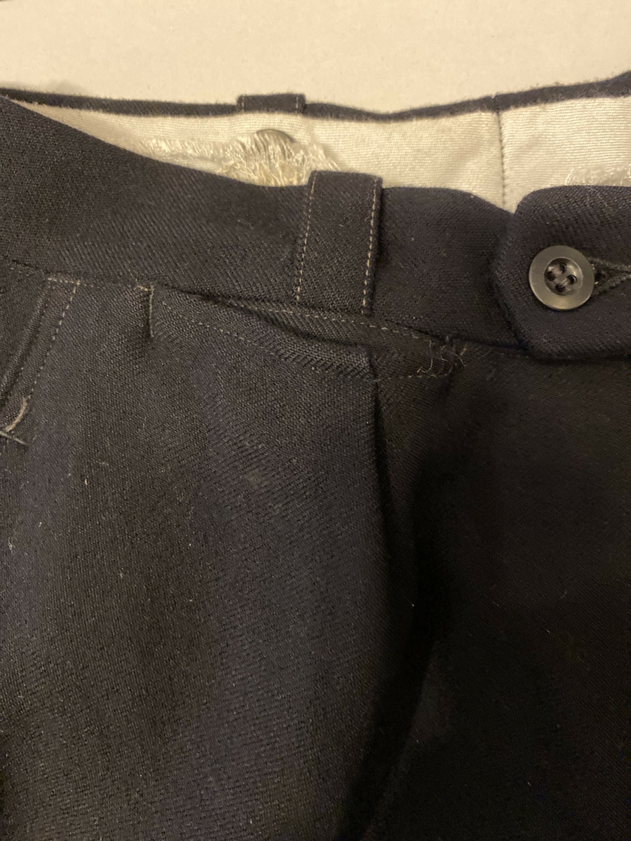Uniformsbukse, del av NSB-uniform. Knappegylf, klokkelomme, sidelommer og baklommer med knapp.