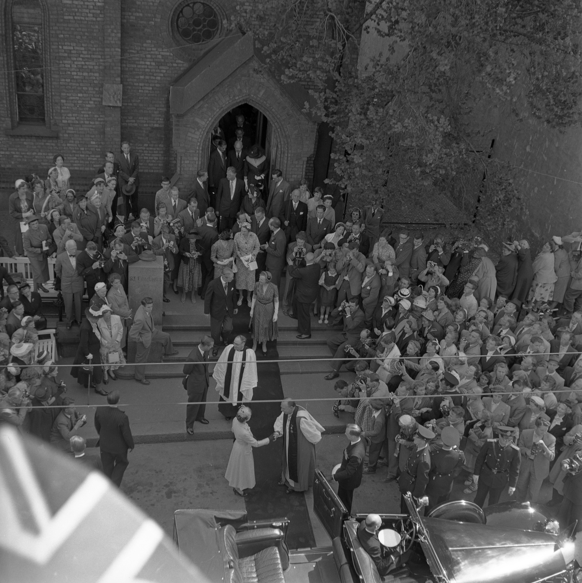 Dronning Elizabeth II på statsbesøk i Norge. Her forlater Dronningen og Prins Philip St. Edmunds Church i Møllergata 30 i Oslo etter en gudstjeneste i kirken. Dronningen tar farvel med biskop Robert Wright Stopford.