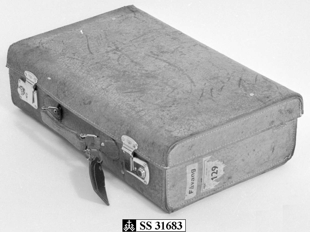 Kofferten har sider, lokk og bunn av papp, kledd med brunt skinn og låser i metall. Den har merkelapper fra produsenten og en lapp med navn og adresse til tidligere bruker festet på håndtaket. Innvendig er den kledd i hvitt tekstil og på lokket er det festet en ekstra lomme med glidelås.