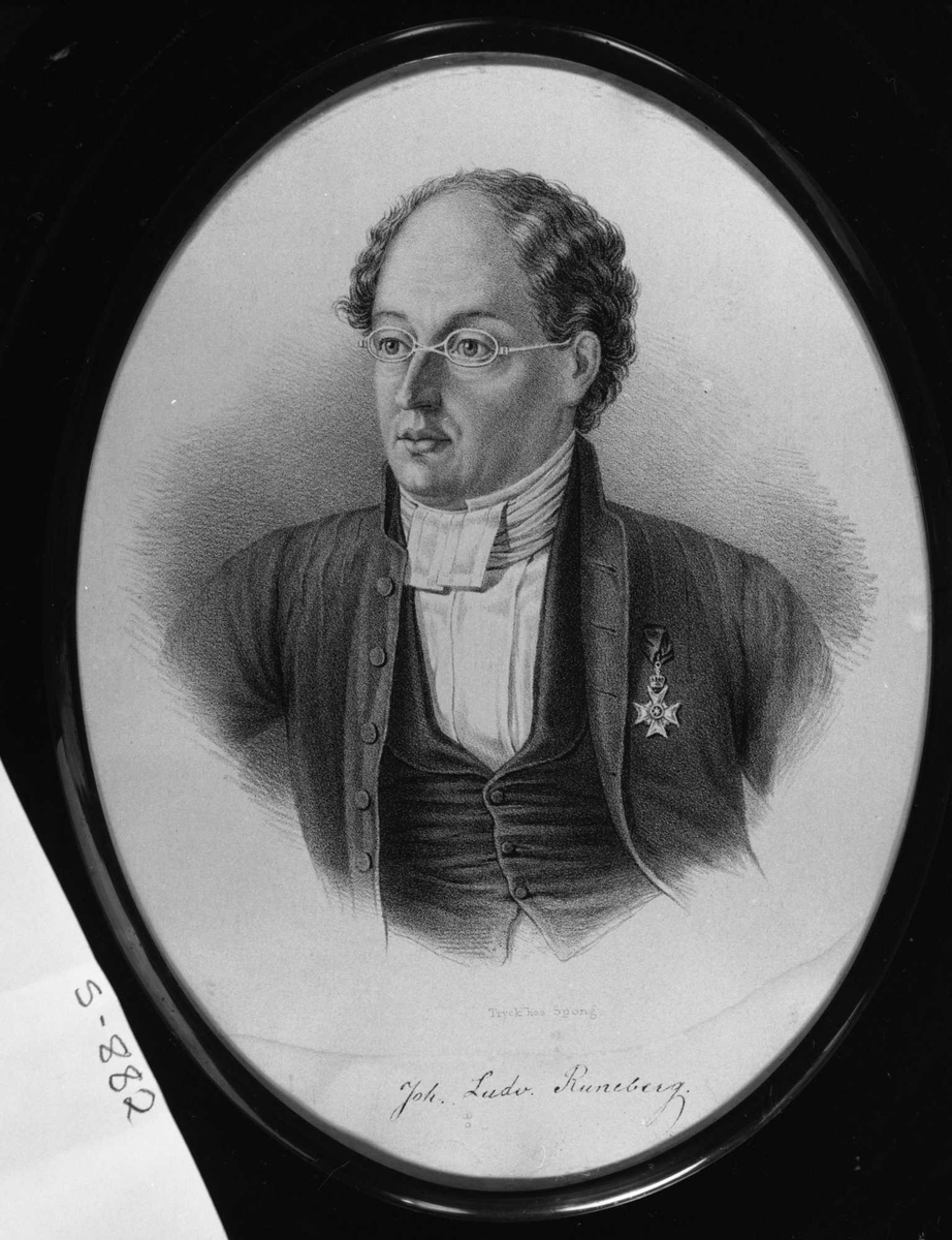 Portrett (brystbilde, 3/4 en face) av mann med smale briller, kledd i dress med halstørkle, orden på brystet.