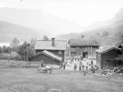 Gården Kolloen med bolighus, driftsbygninger, menn, kvinner,