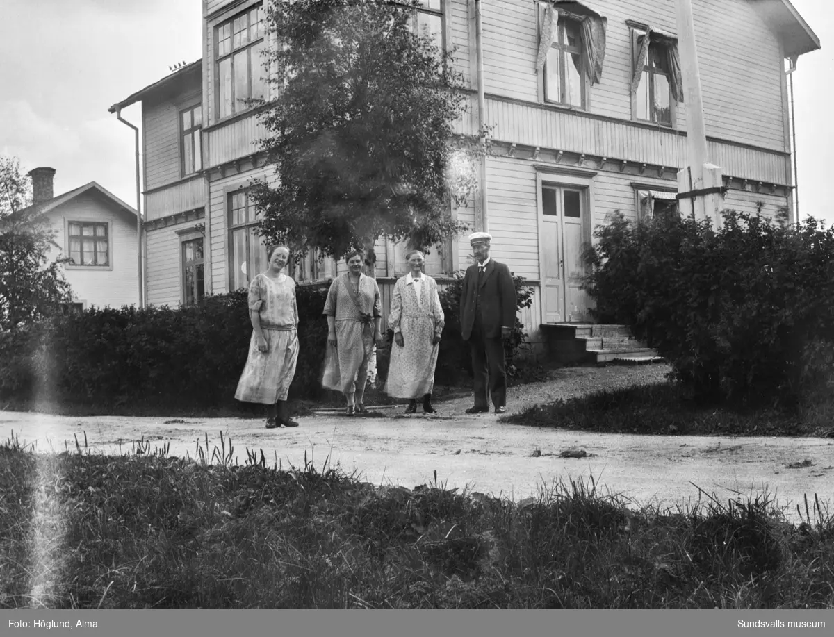 Två bilder av Erik Gustaf, Eva och Göta Bäckström, samt en oidentifierad kvinna, vid hemmet på Hammarn i Fanbyn. På första bilden syns bostadshuset bakom dem och på den andra står dom framför gårdshuset.