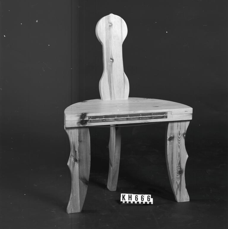 Munkstol som kan användas både som stol och bord då det finns ett mässinggångjärn på mitten. Utslaget H: 450 mm, Diam: 625 mm. 
Märkt "Munkstol från Torsby, från 1970. T. Ternander 1982". Skrift fasttejpad under skivan: "Kållereds Hembygdsförening erhåller härmed en munkstol av familjen Ternander. Denna stol är av 1700-talsmodell och härstammar från Torsby i Värmland, fast något modernare design. Tages Hobby".
Funktion: Tebent stol i stolpkonstruktion med enkelt ryggstöd.