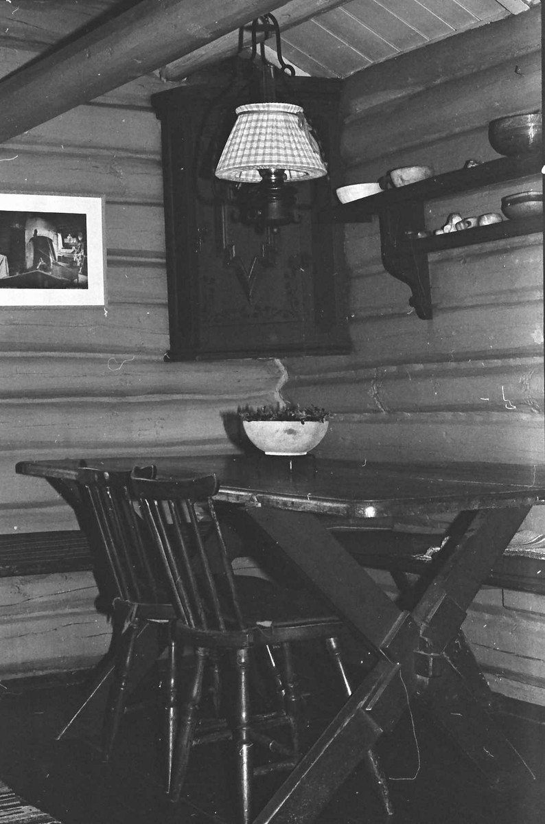 Sæterhus (inne), stoler, bord, lampe, hylle. 