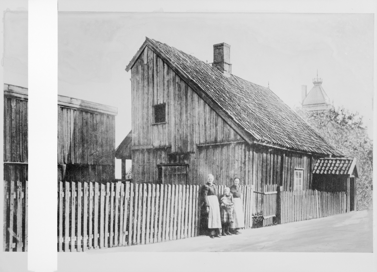 Reprofotografier av fotografier av Lilleborg fabrikker. Et par kvinner og et barn står foran en trebygning.