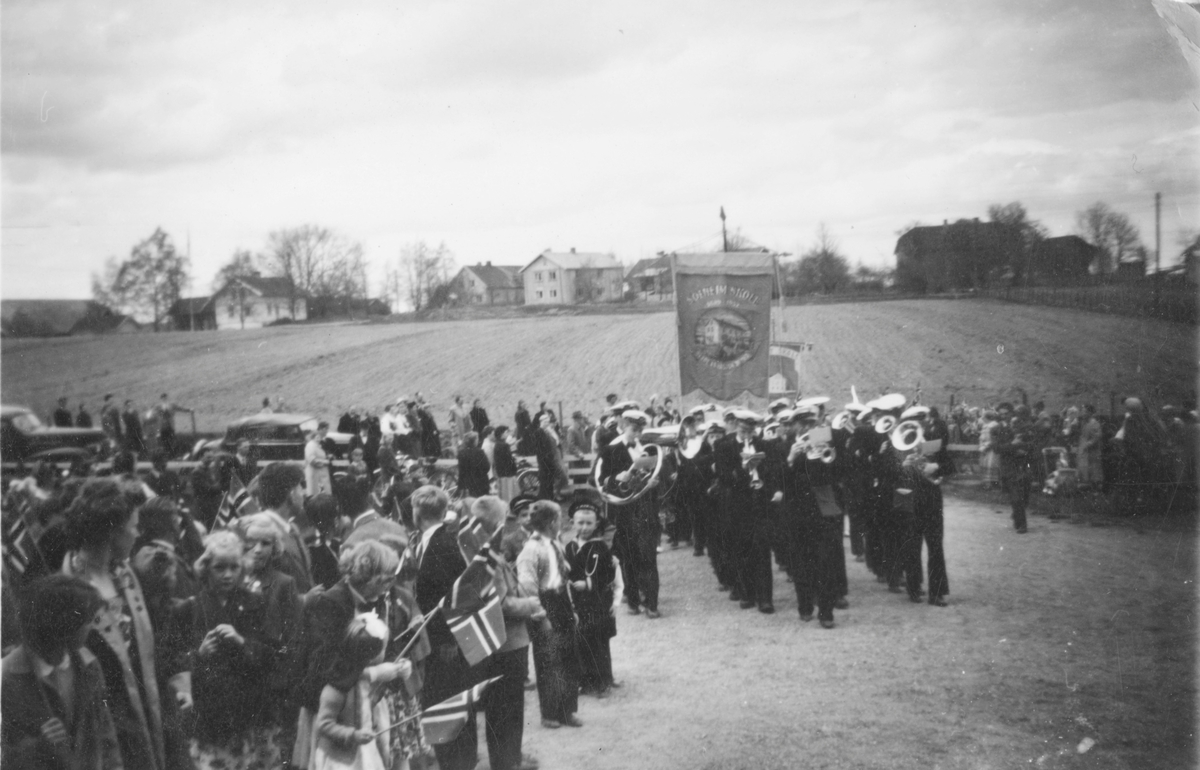 17. mai feiring, korps med fane og barn med flagg ved Gjerdrum kirke.