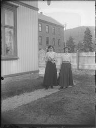 To kvinner stående på gangveg ved Trudvanggården. Stakkittgj