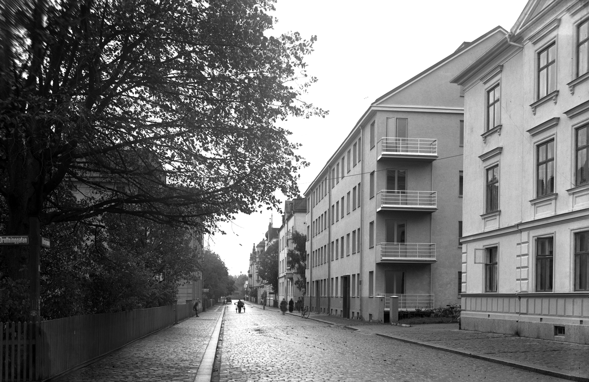 Vy längs med Klostergatan i Linköping en gråmulen sensommardag 1934. Det vid tiden moderna flerfamiljshuset i funktionalistiska stil stod klart 1932 och var ritat av Johan Sandberg (1886-1970).