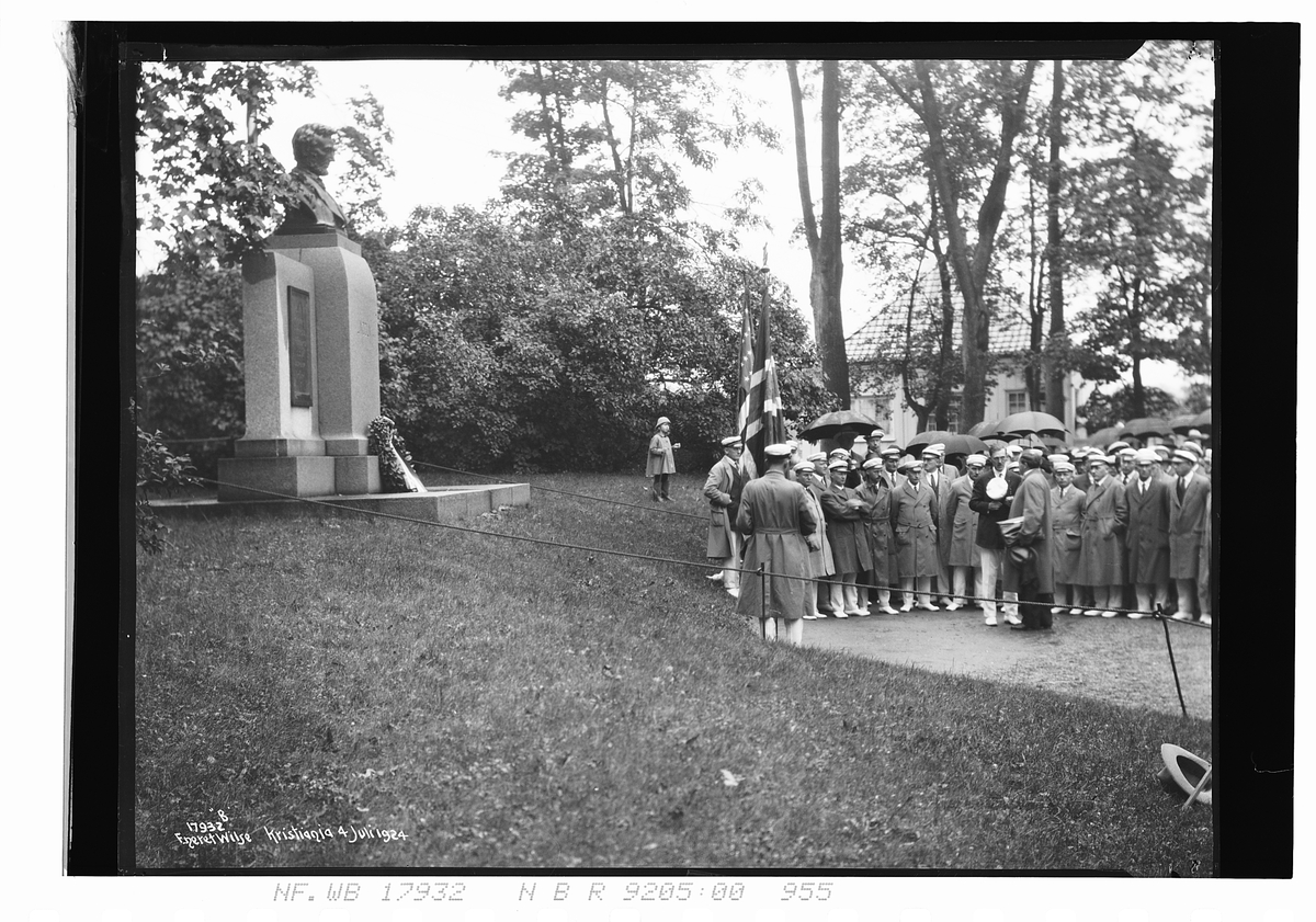 Krans er lagt ned på statue av Abraham Lincoln, mannskor står i bakgrunn. Påskrevet fotografiet "Kristiania 4. juli 1924".