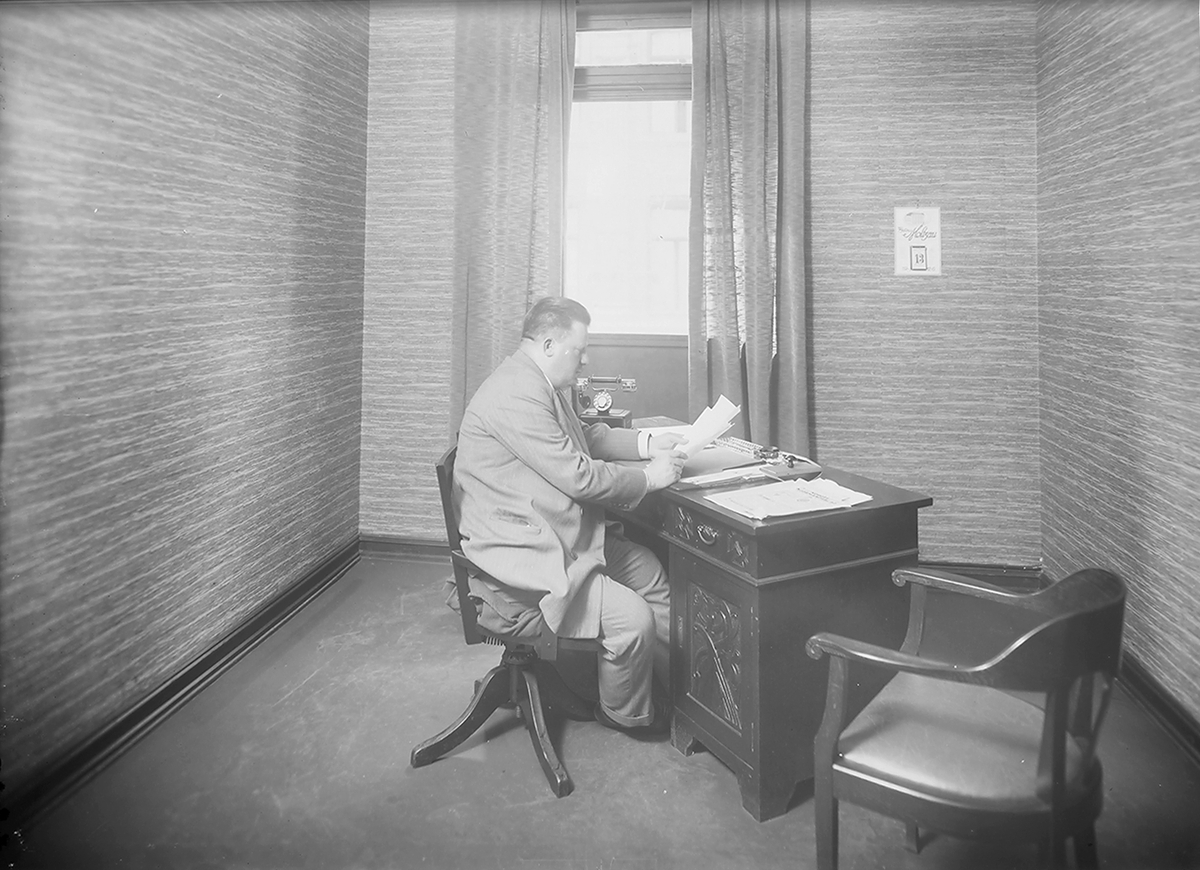 Mann ved skrivebord på kontor til Norsk kaffekompani. Fotografert 1924.