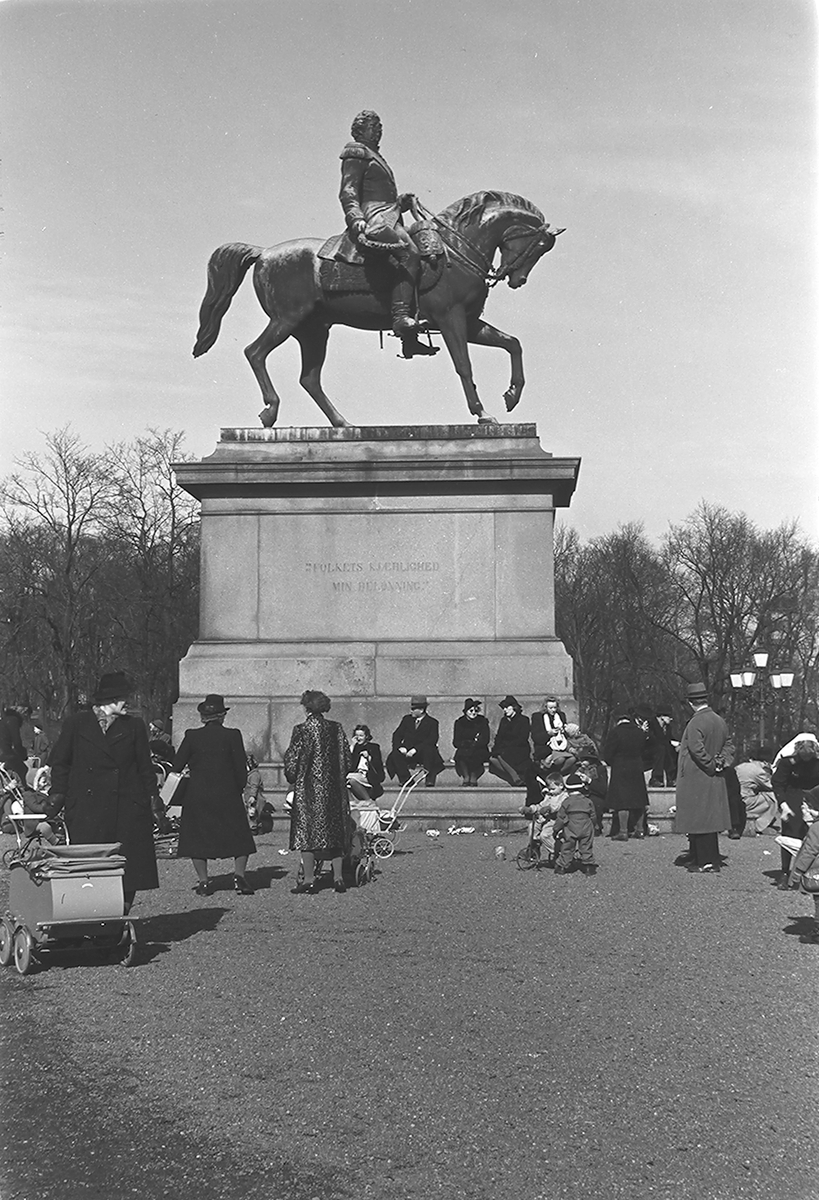 Personer ved Karl III Johans statue på Slottsplassen, Oslo. Fotografert 1940.