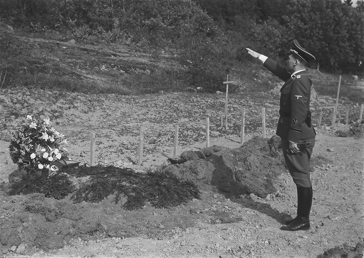 Tysk nazist gjør nazihilsen foran nazigrav. Fotografert 1940.