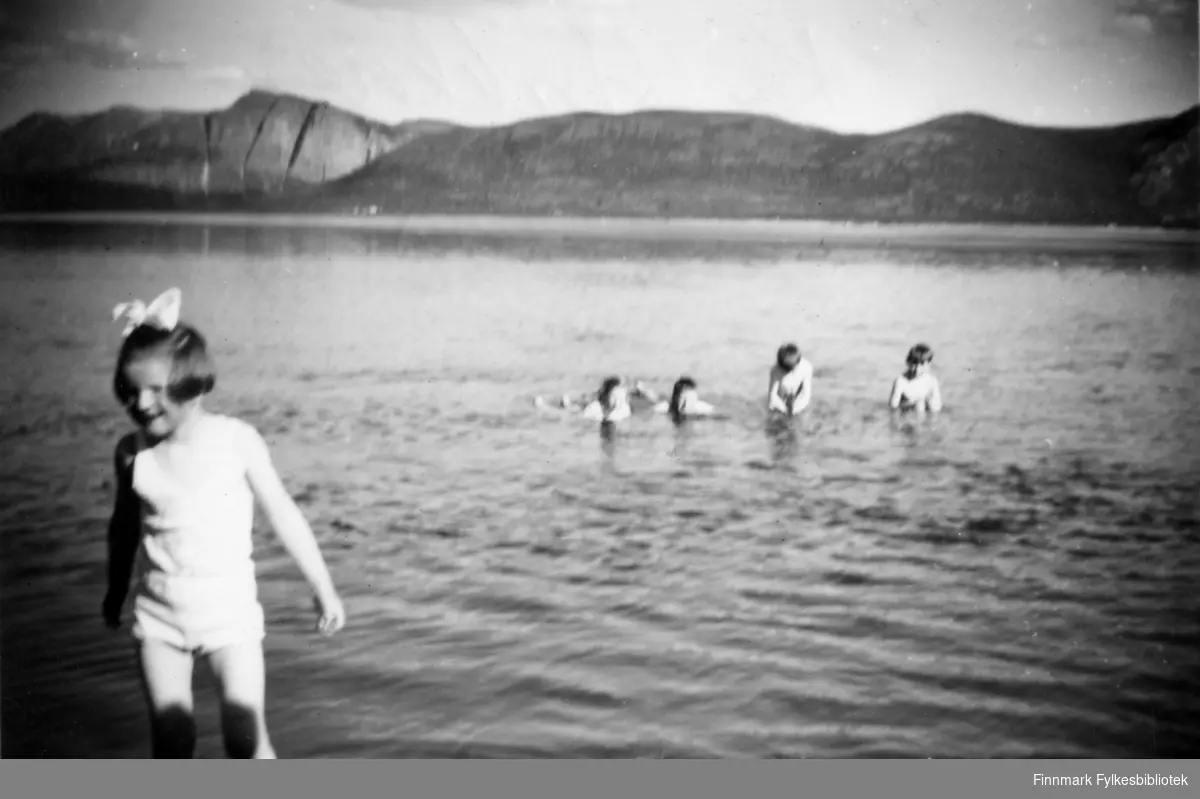 Kaldbakknes i Tana sommeren 1960. Barn bader, Svanhild Karlsen foran på bildet. Andre siden av stranden Høyholmen.