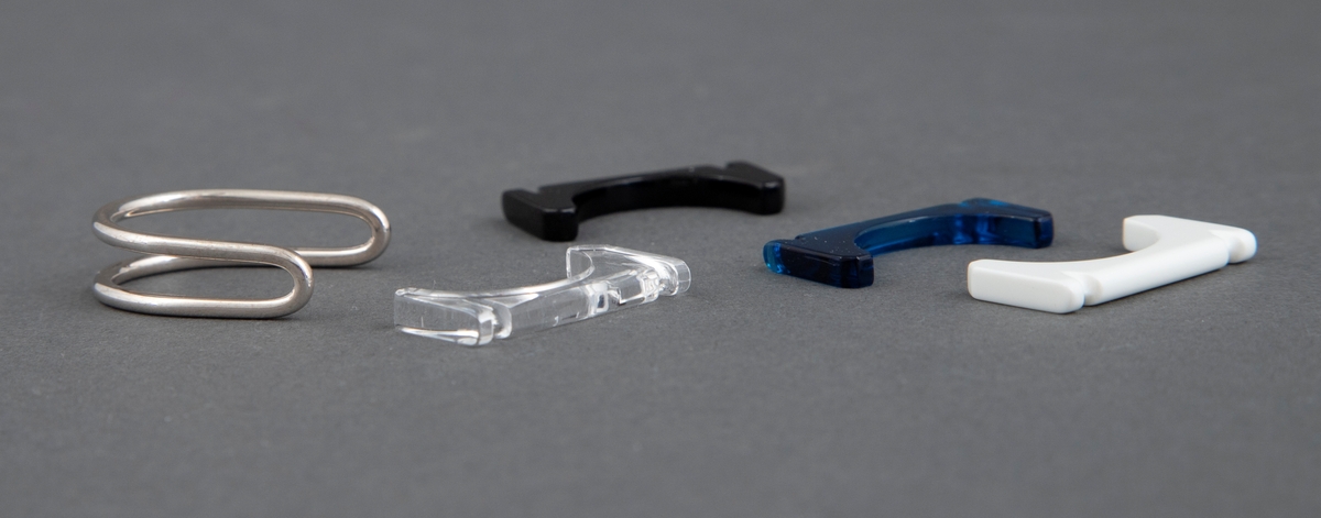 Ring bestående av et sølvbånd som er lagt dobbelt, bøyd i en dyp halvsirkelform og avrundet i begge ender. Det hører med fire utskiftbare deler av akryl. Disse er beregnet til å settes inn i sølvdelens åpne side, slik at det dannes en ring. Akryldelene er rett på den ene siden, konkav på den andre. 
De har fargene blank, hvit, blå og svart, slik at ringen kan brukes med forskjellig farge.