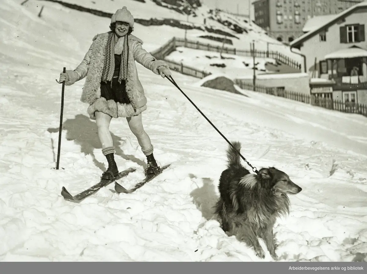 "Christmas at St. Moritz". Kunstløpersken Hilda Rückert (1897 - 1960) og hund på tur i snøen. Udatert