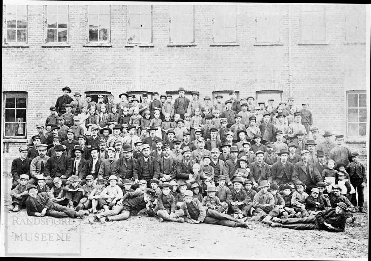 Arbeidere ved Hadeland Glassverk, oppstilt foran fabrikken.