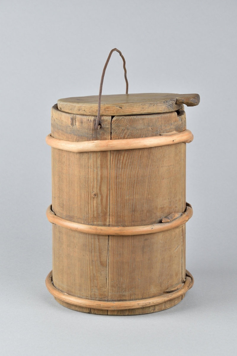 Mjölkbytta tillverkad i trä. Cylinderformat laggkärl med fem stavar och tre utanpåliggande vidjor. Med löstagbart runt lock, samt ett handtag av järntråd. Mjölkbyttans undersidan med inskurna mönster samt årtalet "1821". 