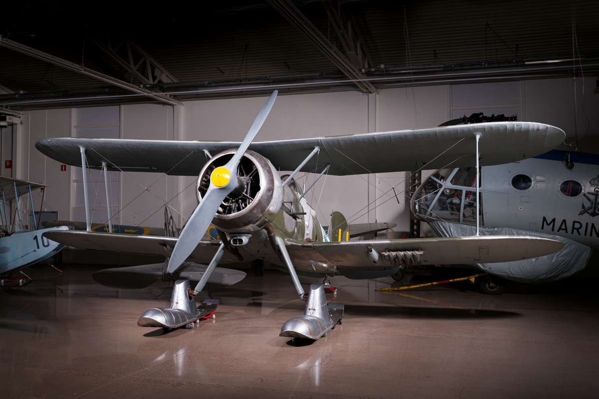 Jaktflygplan, J 8A
Gloster Gladiator.

Ensitsigt biplan med Bristol Mercury S3 motor. Beväpning: 4 x 8 mm kulsprutor samt bomber. 
Märkning: Gult H på rodret och blå svastika på vit bakgrund på sidan.