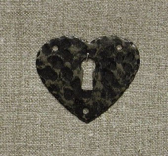 Nyckelhålsbeslag i svart smide föreställande ett hjärta.