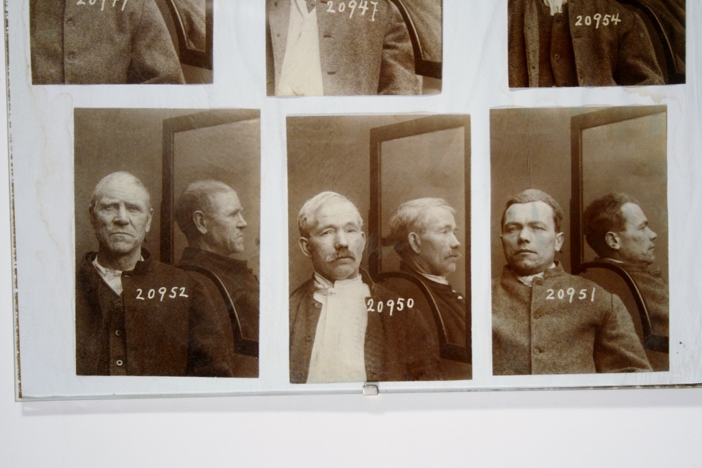 8 forbryterportretter samlet i en ramme.