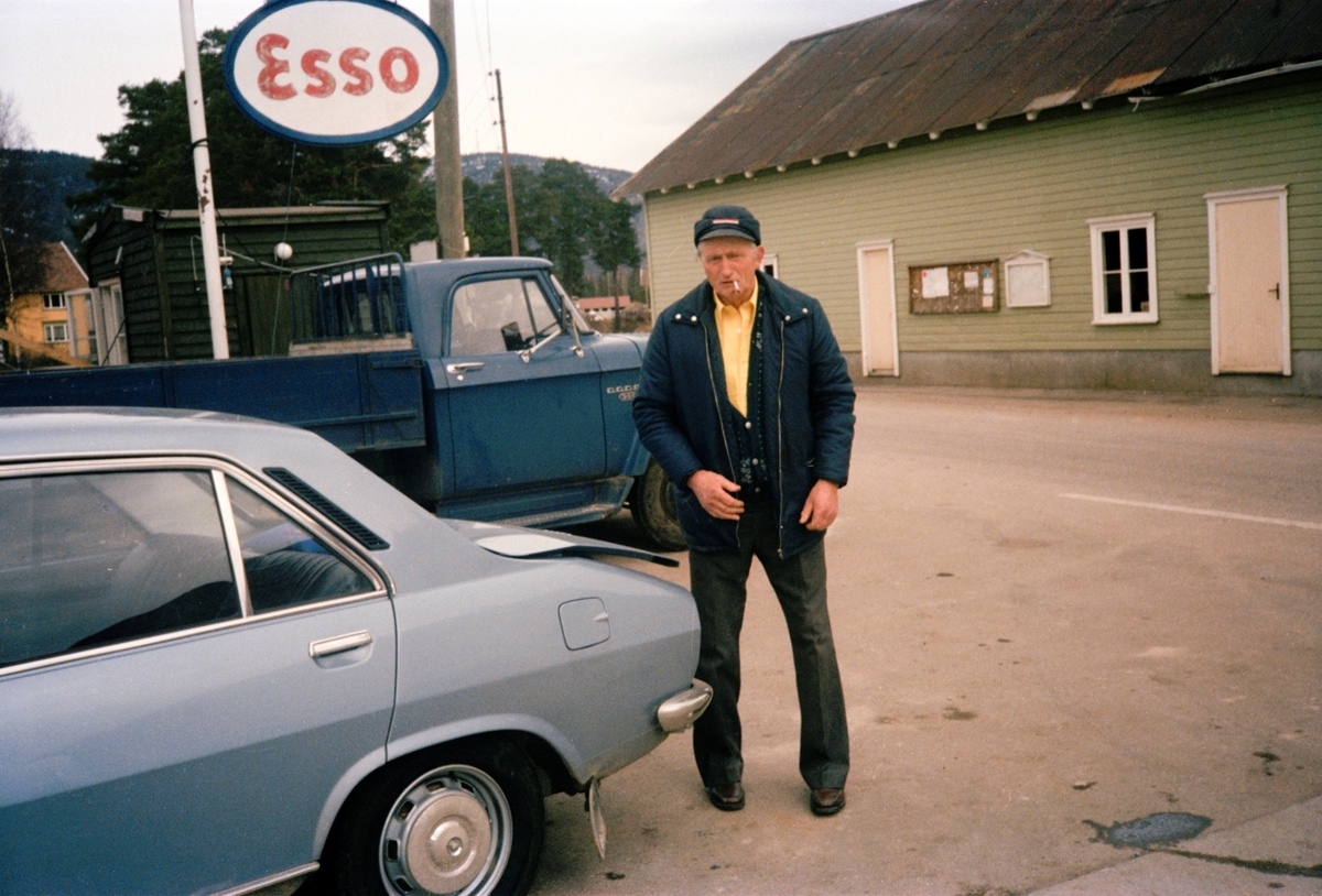 Fra fotoboken "Radius 500 Metres", hvor Terje Abusdal tar utgangspunkt i arkivet etter sin egen bestefar, Åsmund Abusdal. Mann med røyk utenfor ESSO-stasjonen.